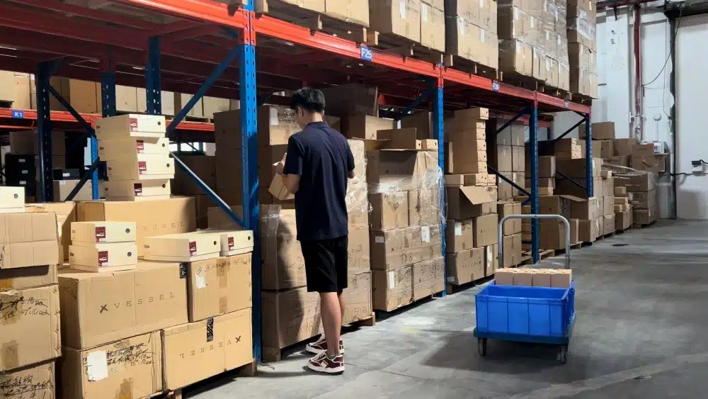 Ecommerce fulfillment worker managing warehouse inventory with shelving systems for TikTok Shop cross-border order processing