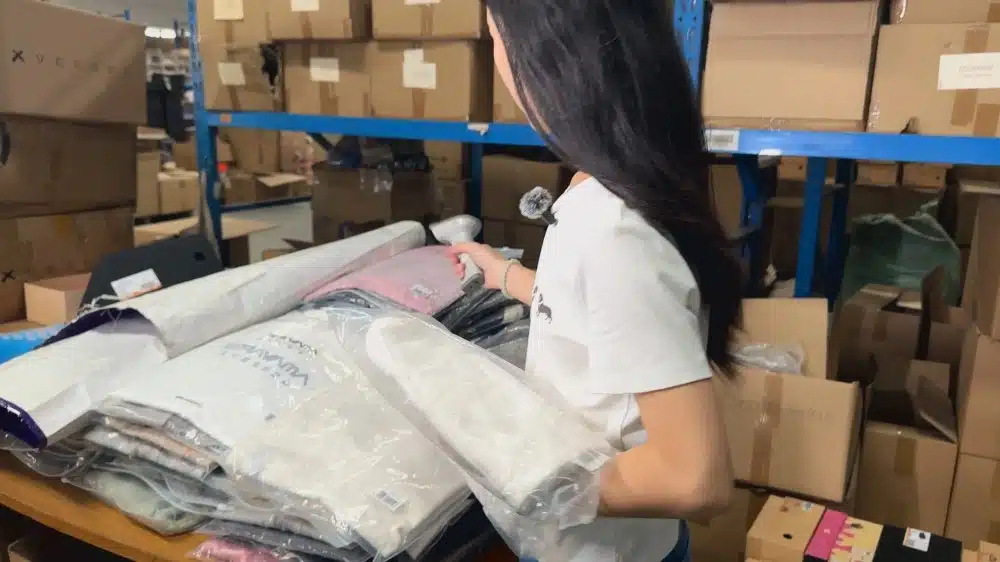 Warehouse worker picking and organizing apparel products for eCommerce order fulfillment and inventory management