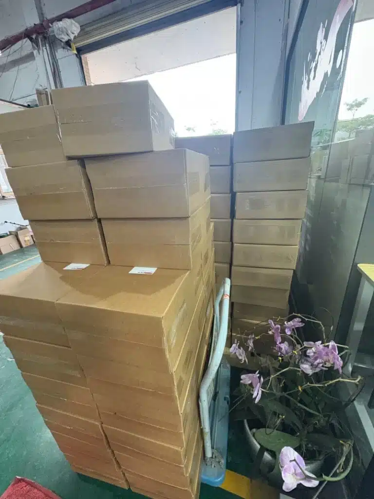 Large stacks of plain cardboard boxes on pallets near a warehouse loading dock, demonstrating scalable fulfillment center operations for small business inventory management and rapid order processing