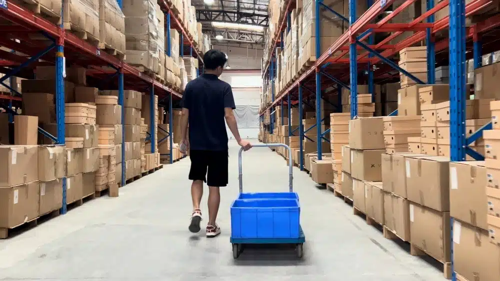 Warehouse aisle with stacked cardboard inventory supporting sustainable packaging management and green ecommerce fulfillment operations