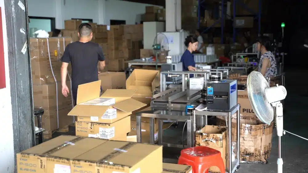 Workers preparing cardboard boxes in a warehouse for FSC certified packaging, ecommerce fulfillment, and sustainable shipping solutions