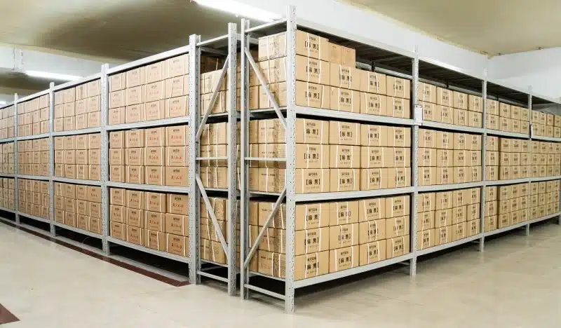 Neatly arranged cardboard boxes on industrial metal shelving units in a professional small business warehousing facility, showcasing organized inventory management and efficient storage solutions for e-commerce operations