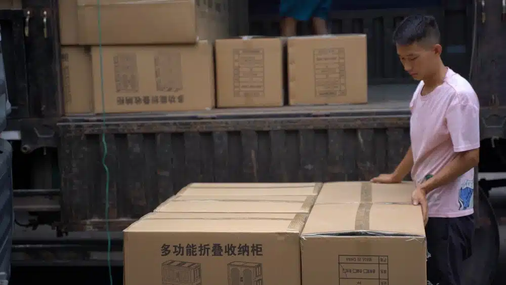 Warehouse worker handling cardboard shipping boxes as part of plastic-free packaging and sustainable ecommerce fulfillment operations
