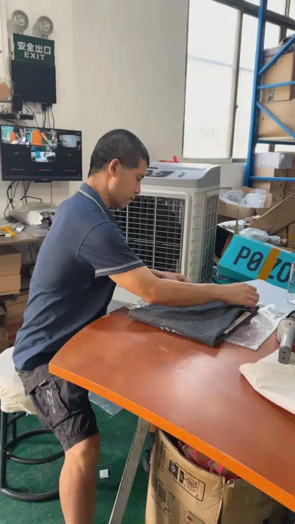 Warehouse employee inspecting and organizing apparel products during inventory control and fulfillment operations