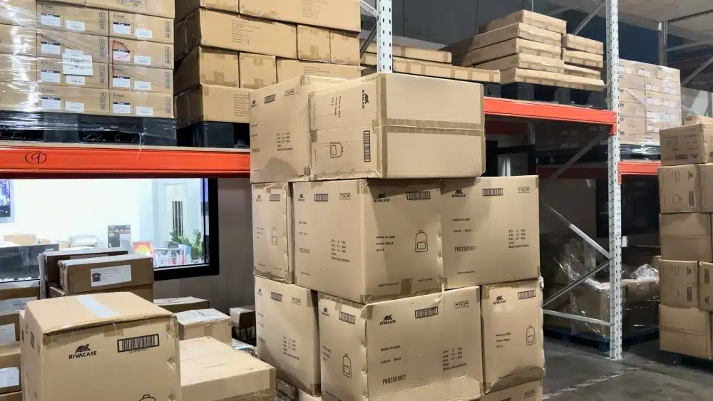 Stacked cardboard boxes in a warehouse showing sustainable paper packaging inventory for FSC certified shipping and fulfillment services