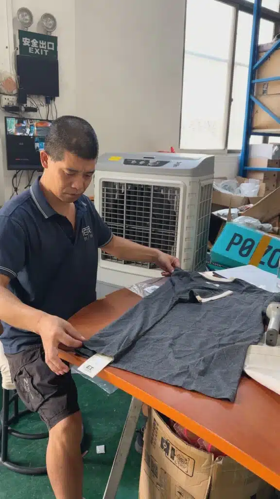 Warehouse worker performing apparel quality inspection for TikTok Shop fulfillment before products are packed and shipped to customers