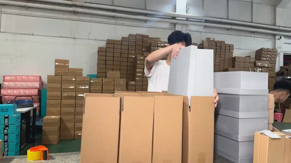 Warehouse worker packing products in a fulfillment center to improve order processing speed and shipping efficiency