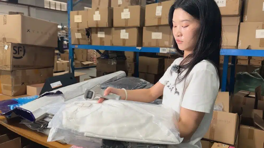 Warehouse worker scanning and checking apparel products with barcode technology for inventory control and fulfillment management