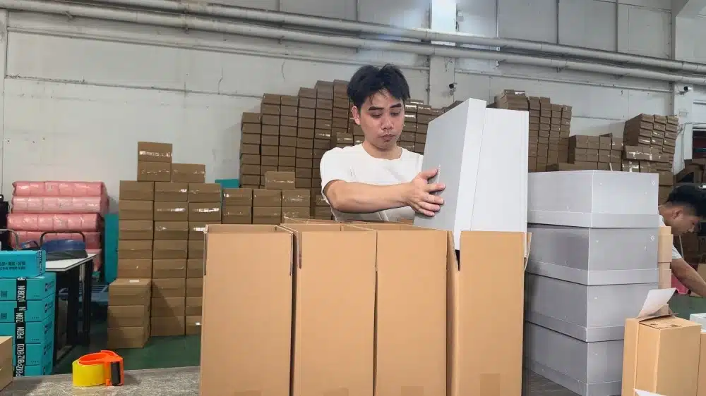 Warehouse staff packing products into boxes as part of professional order fulfillment and logistics operations